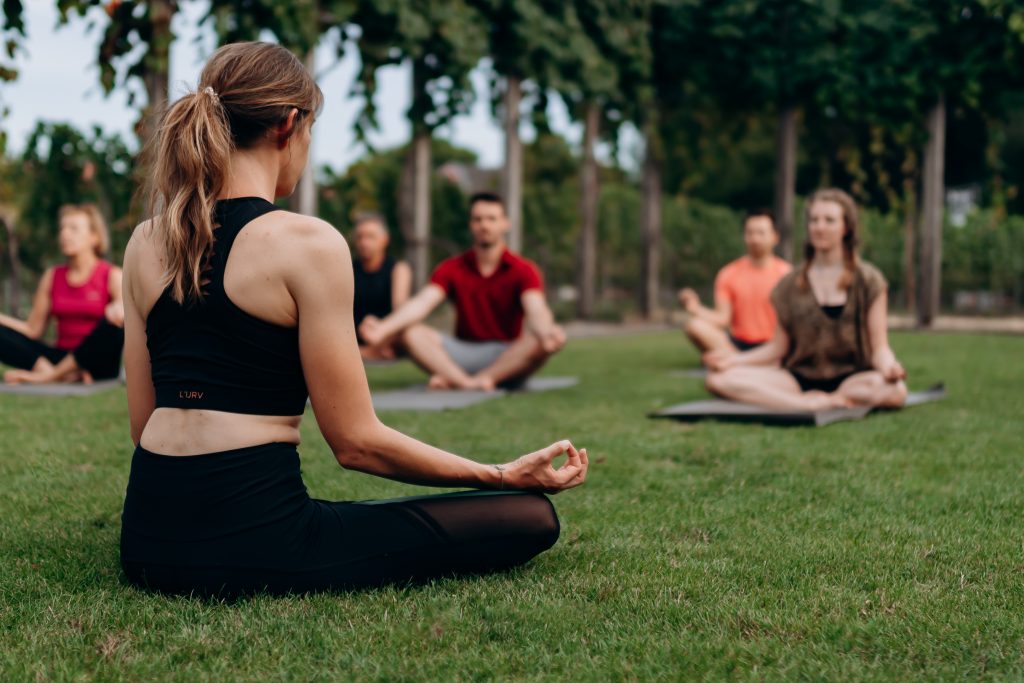 Sophie, eine Yoga-Lehrerin, beim Ausführen einer Yoga-Pose bei einer WineYoga Session.